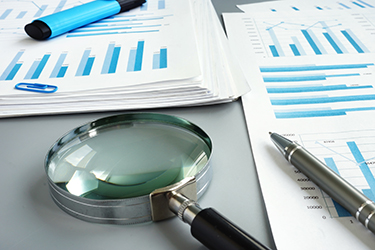 Magnifying glass and business report for auditing. Person clicking on bar graph