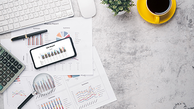 Smart phone with charts and reports on office desk workplace. To Smart phone with charts and reports on office desk workplace. Top view flat lay
