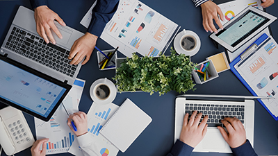 Top view of business entrepreneurs analyzing company graphs documents developing financial strategy Top view of business entrepreneurs analyzing company graphs documents developing financial strategy working in startup office. Teamwork planning management investment brainstorming infographics