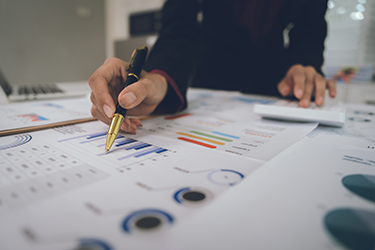 A businesswoman analyzes financial documents with charts and gra A businesswoman analyzes financial documents with charts and graphs