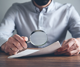 man hand document with magnifier on desk man hand document with magnifier on desk