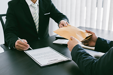 The businessman cheated money by accepting the bribe money insid The businessman cheated money by accepting the bribe money inside the brown envelope. To deliver success in investment contracts, bribery and corruption.