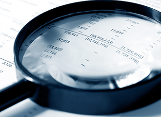 Magnifying glass over financial figures.  Shallow DOF, cyan tone.