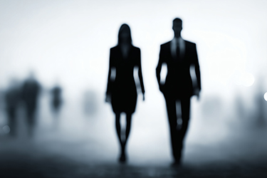 Silhouettes of business people, Walking in foggy background, Symbolic of leadership or corporate vision Silhouettes of business people, Walking in foggy background, Symbolic of leadership or corporate vision