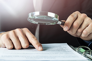 Business analytics and statistics. Businessman with report using Business analytics and statistics. Businessman with report using a magnifying glass.