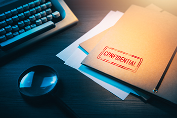 private detective desk with envelopes labeled as confidential Private investigator desk with confidential envelopes