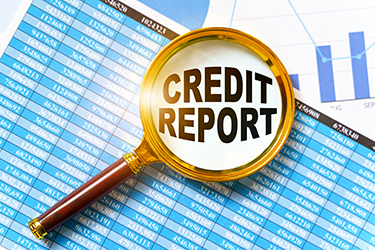 Finance and business concept. Financial reports, charts and a magnifying glass are on the table. Inside the magnifier there is an inscription - CREDIT REPORT