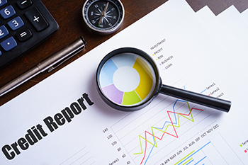 Magnifying glass on colorful pie chart with "Credit report" 